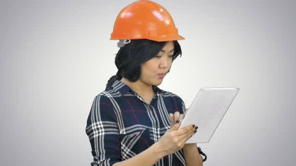 Aziatische ingenieur vrouw met behulp van Tablet PC op witte achtergrond — Stockvideo
