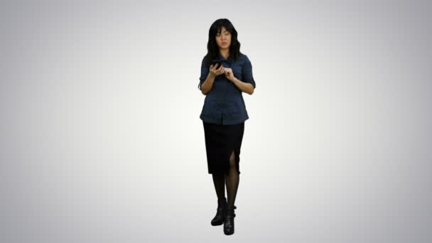 Les jeunes femmes asiatiques debout avec smartphone et parler à une caméra sur fond blanc — Video