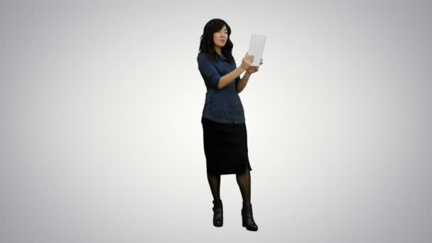 Asya Bayan Beyaz arka plan üzerinde bir tablet kullanarak görüntülü sohbet sahip — Stok video
