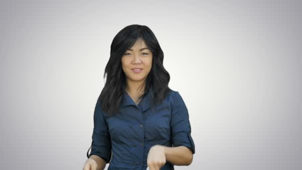 Vacker asiatisk tjej skrattar kasta bitar av papper på vit bakgrund — Stockvideo
