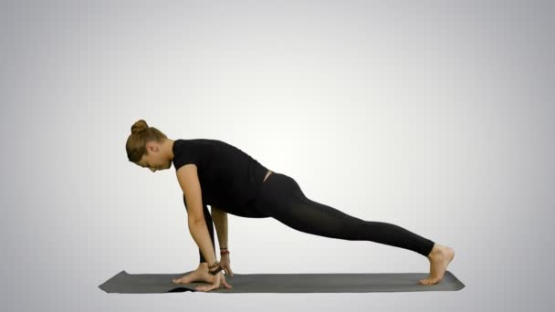 Jovem mulher bonita vestindo sportswear preto trabalhando fora, fazendo ioga ou exercício pilates no fundo branco — Vídeo de Stock