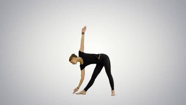 Спортивная красивая улыбающаяся молодая женщина, стоящая в Utthita Trikonasana, расширенный треугольник Поза на белом фоне — стоковое видео