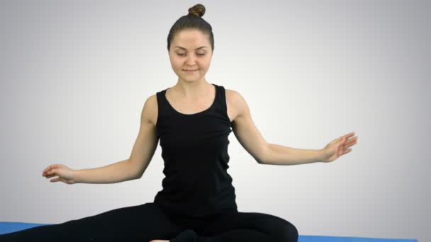 Mulher fitness esticando seu corpo fazendo pilates no fundo branco — Vídeo de Stock