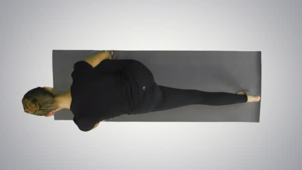 Ung kvinna stretching kropp, titta på kameran ovanför på vit bakgrund — Stockvideo