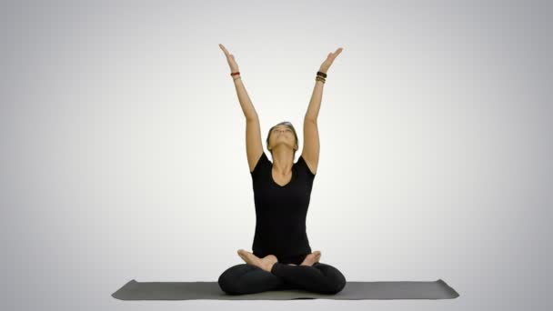 Woman practicing yoga in lotus pose with namaste hands gesture on white background — Stock Video