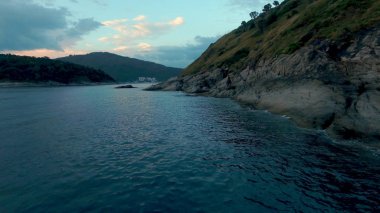 Kamera denizde kayalar etrafında uçar