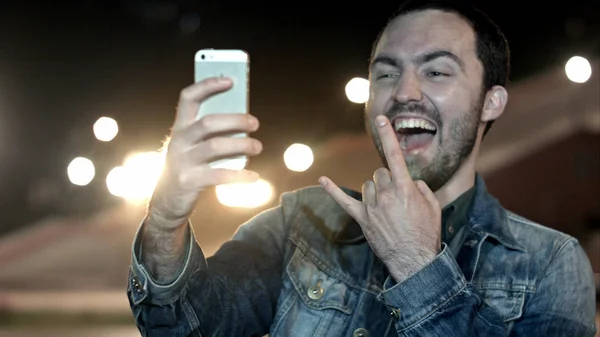 Hombre tomando autorretrato en la ciudad nocturna con teléfono móvil — Foto de Stock