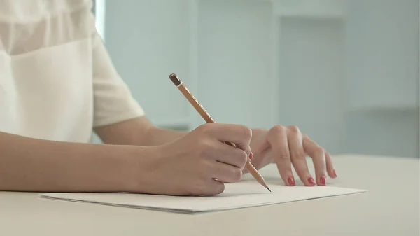 Kvinna med penna skriva på papper — Stockfoto
