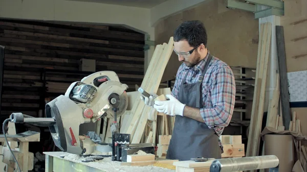 Carpintero trabajando tablón de madera en taller . — Foto de Stock