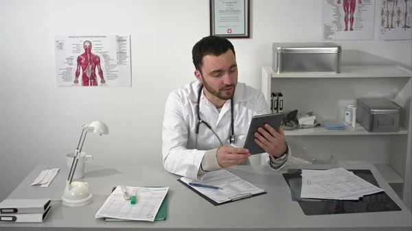 Male doctor having video conference useing tablet gadget — Stock Photo, Image