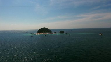 Helikopter dolu insanlar ve tekneler sahile yaz gününde uçar.