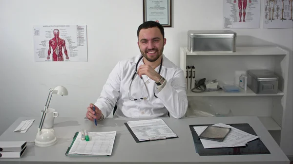 Дружній чоловік лікар дивиться на вузли камери і посміхається — стокове фото