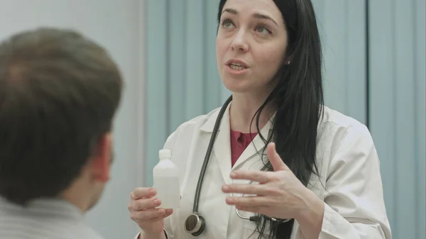 Γυναίκα γιατρό συνιστώντας και μιλά για την επίδραση των φαρμάκων στον ασθενή — Φωτογραφία Αρχείου