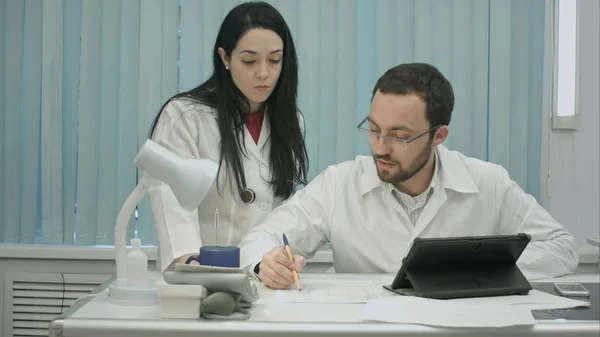 Les médecins masculins et féminins discutent du document médical — Photo