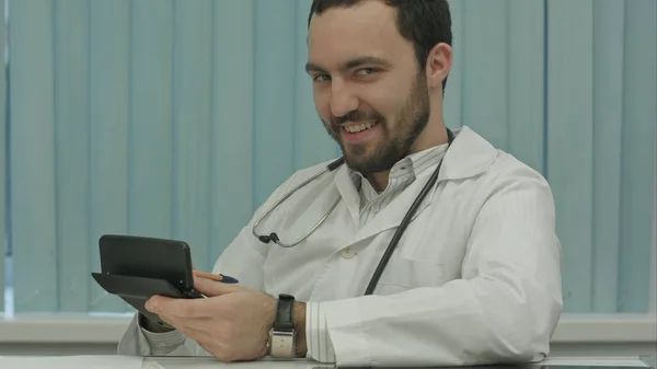 Sinister bearded doctor with a calculator. calculation of price — Stock Photo, Image