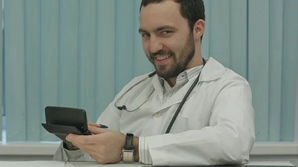 Médico barbudo sinistro com uma calculadora. cálculo do preço — Fotografia de Stock