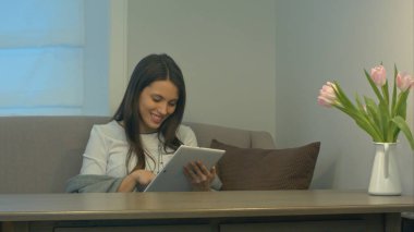 Touchpad kullanarak ve gülümseyen koltukta oturan çekici kız