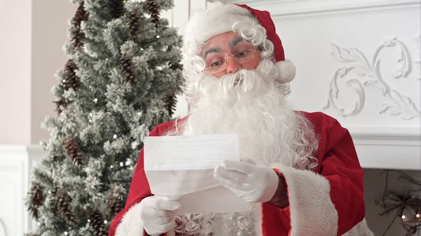 Jultomten som sitter i sin verkstad som läser ett brev — Stockfoto