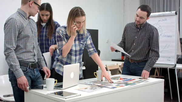 Designers falando no telefone com o cliente ao selecionar cores da paleta — Fotografia de Stock