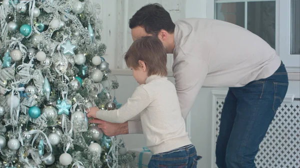 Apa és fia baubles a nappaliban a karácsonyfa díszítése — Stock Fotó