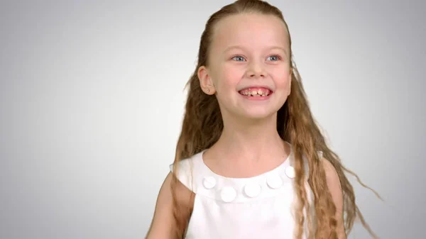 Jugar, saltar niña en vestido blanco disfruta del juego en el fondo blanco — Foto de Stock