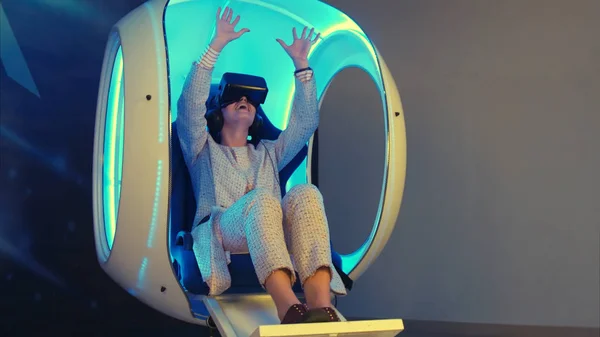 Emocionální žena zažívá virtuální realita v pohyblivé interaktivní židli — Stock fotografie