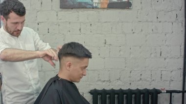 Berber dükkanı harika zaman. Neşeli Genç sakallı adam saçlarını Kuaför tarafından elde