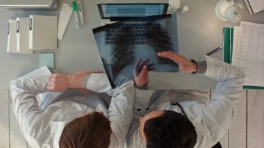 Doktorların tıbbi ofis, bağırsak xray tartışırken üstten görünüm