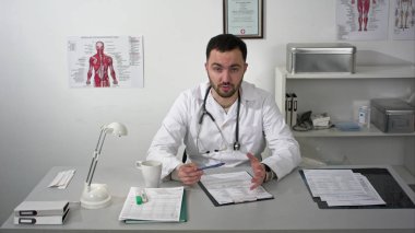 Sakallı doktor sessizce kameraya açıklayan