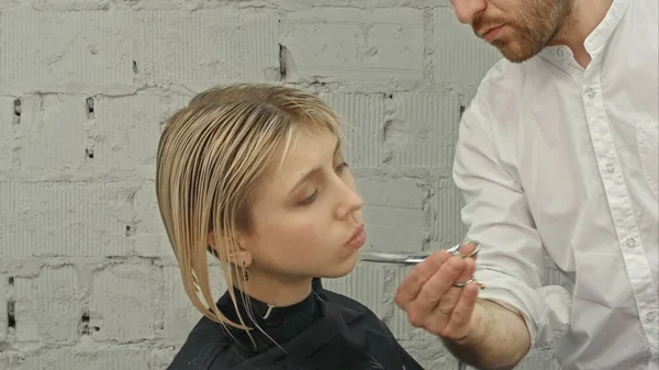 Giovane bella donna che si fa tagliare i capelli dai parrucchieri. — Foto Stock
