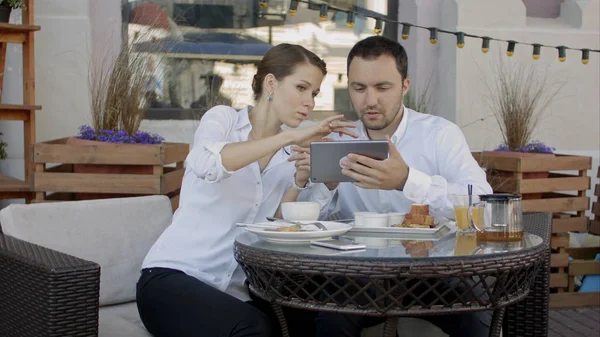 Két fiatal üzletemberek segítségével digitális tábla egy kávézóban találkozó — Stock Fotó