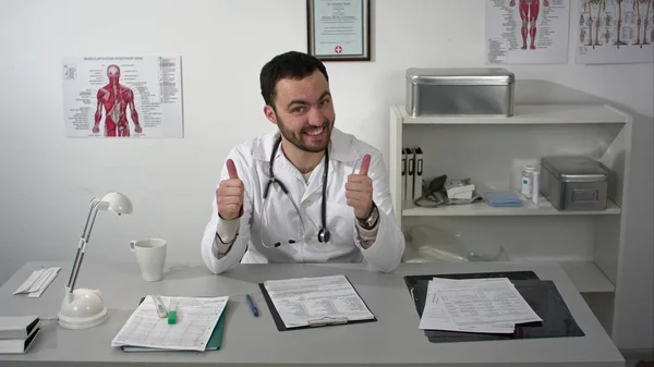 Улыбающийся доктор показывает большие пальцы вверх — стоковое фото