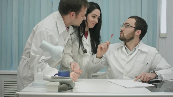 Deux médecins de bonne humeur discutent de quelque chose dans Internet au centre médical, puis vient stagiaire — Photo