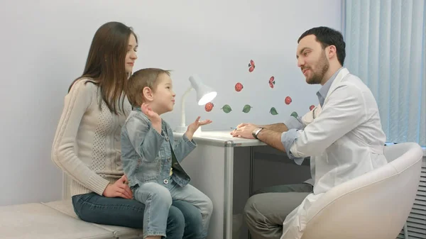 Doctor hablando con el niño pequeño y la madre — Foto de Stock