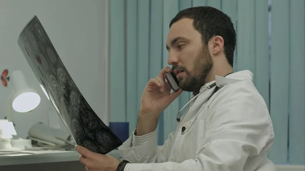 Médico masculino hablando por celular en un hospital moderno en el interior — Foto de Stock