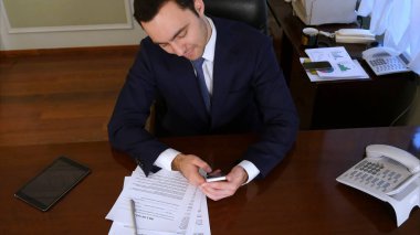 Smartphone kontrol, iyi haber okuma ve gülümseyen ABD'li iş adamı