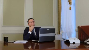 Dizüstü bilgisayarda çalışma, dinlenme ve office kollarında germe yorgun iş adamı bitirir