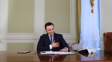 Telefon görüşmeleri katılıyor ve evrak işi işadamı overworked ve aniden onun kalbinde derin bir acı vardır