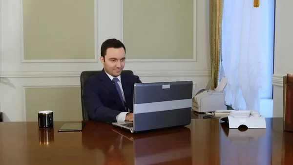 Trabajador europeo escribiendo en el teclado y mirando el monitor del portátil — Foto de Stock