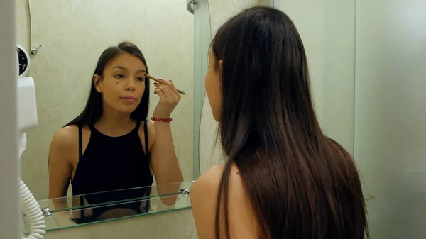 Retrato de niña aplicando polvo de sombra de ojos, que prefigura para la fecha — Foto de Stock