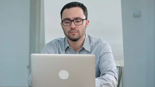 Knappe mannelijke leraar in glazen typen op laptop — Stockfoto