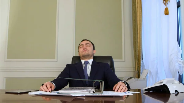 Перевантажений бізнесмен засинає в офісі — стокове фото