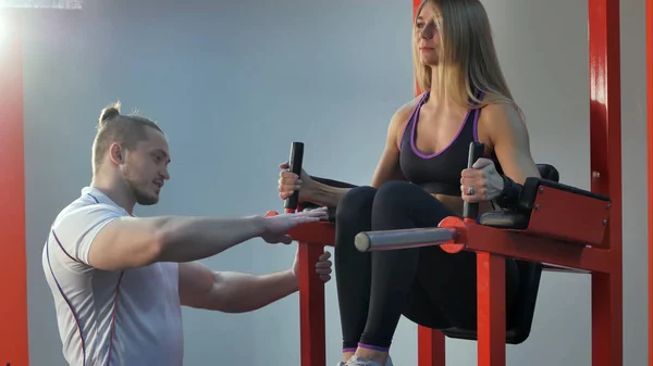 Personal trainer correcting his client during exercise in the gym — Stock Photo, Image