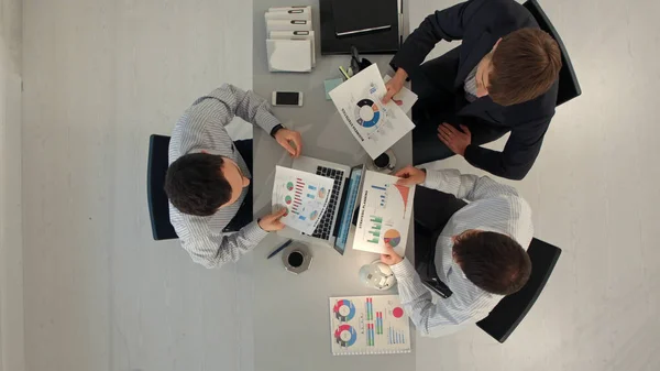 Equipe criativa exibindo gráficos com laptop e tablet pc computadores sentados à mesa no escritório. Vista superior — Fotografia de Stock