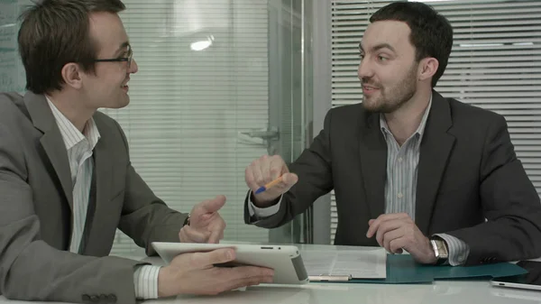 Image de deux jeunes hommes d'affaires utilisant le pavé tactile à la réunion — Photo