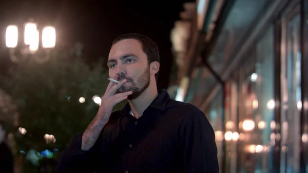Hombre fumando en la ciudad nocturna — Foto de Stock