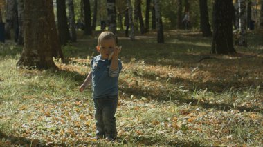 Sevimli çocuk cep telefonu ile konuşurken çalışır.