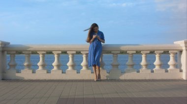 Mavi elbise manifatura iletisindeki gülümseyen kız.