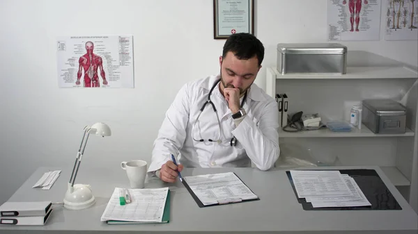 Thinking out loud. Thoughtful young bearded doctor in medical cabinet. — Stock Photo, Image