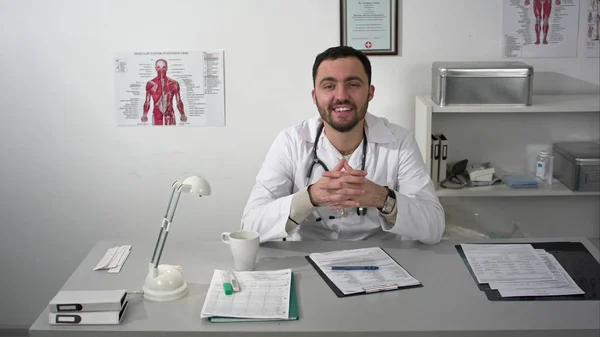 Friendly doctor talking to camera